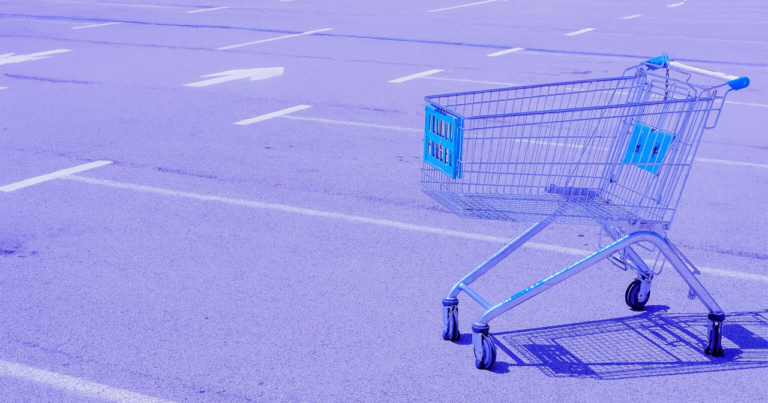 Carrinho de compras vazio em estacionamento simbolizando abandono de carrinho.