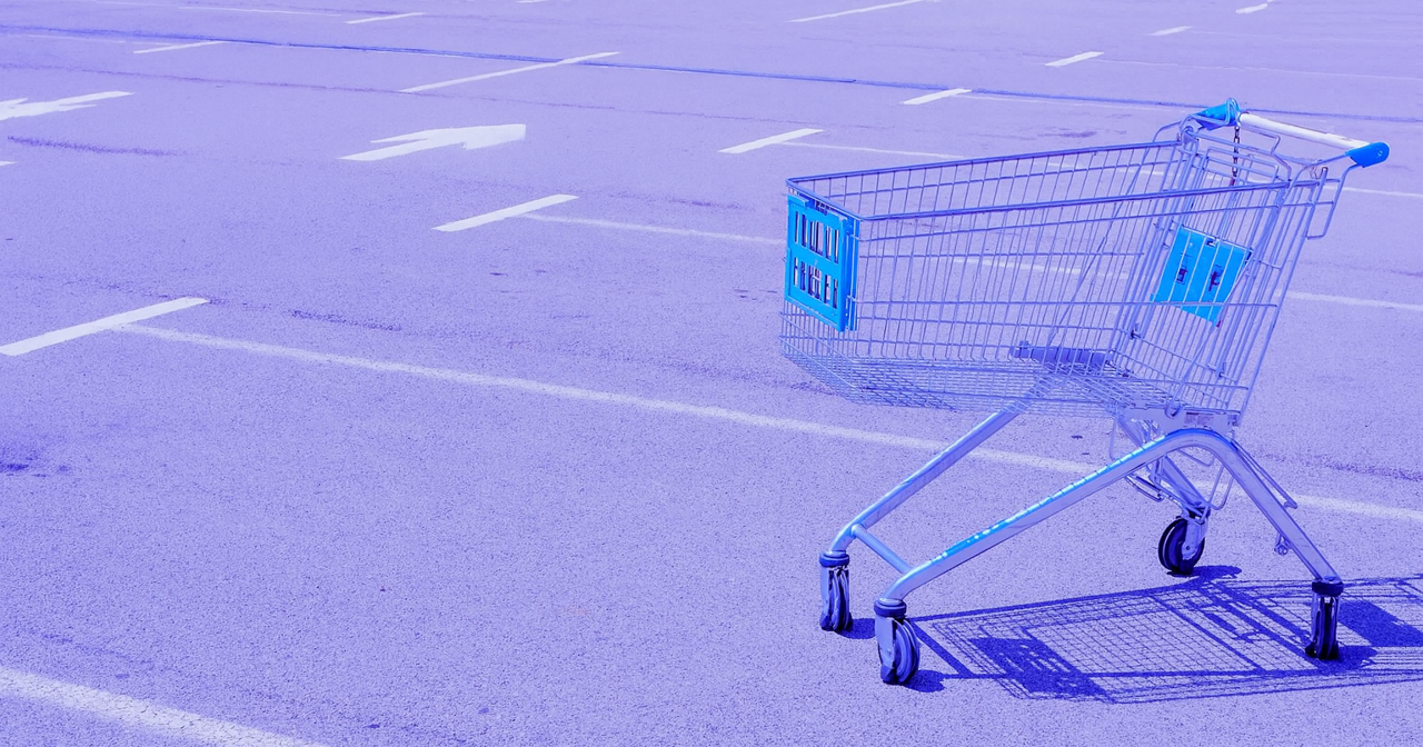Carrinho de compras vazio em estacionamento simbolizando abandono de carrinho.