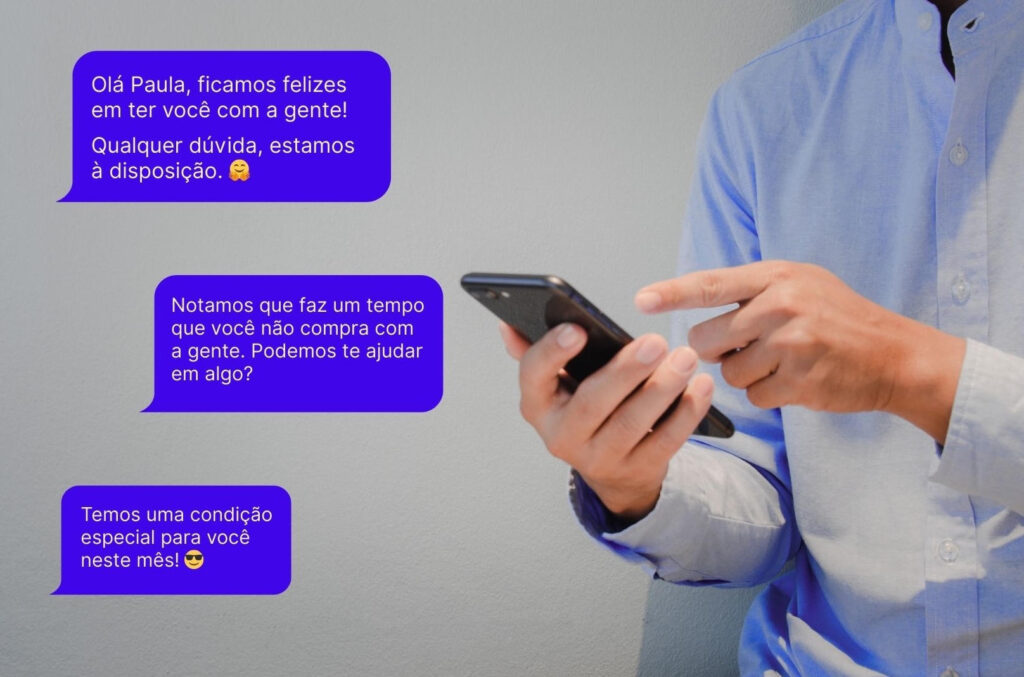 Homem segurando celular com mensagens automáticas de pós-venda.