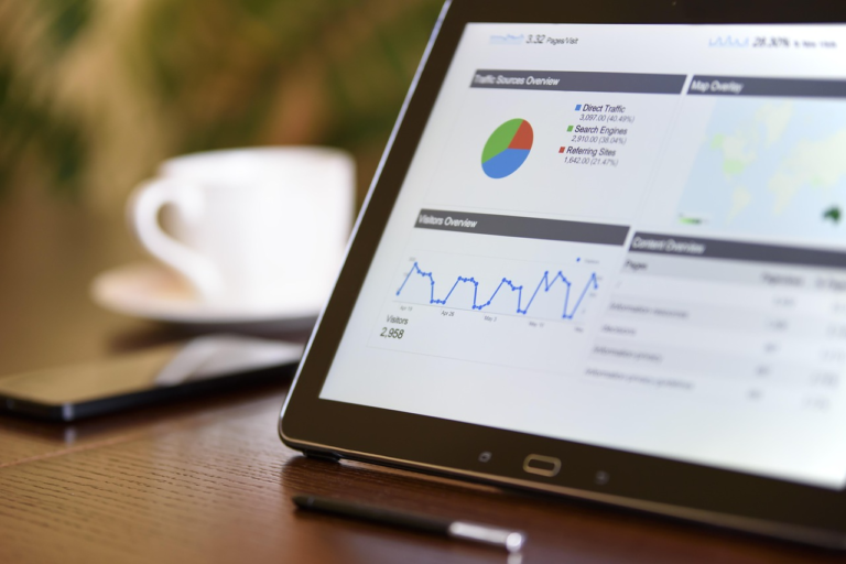Tablet exibindo painel de métricas de marketing digital com gráficos de tráfego e desempenho.